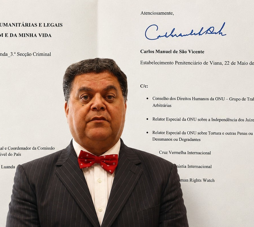 Fotografia em plano médio do empresário angolano Carlos Manuel de São Vicente. Ele veste um fato (terno) escuro, camisa branca e gravata de padrão discreto. Está posicionado em um ambiente interno iluminado, olhando diretamente para a câmera com uma expressão séria e formal.