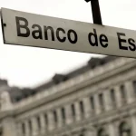 Vista urbana de Madrid com gráficos económicos representando crescimento do PIB e inflação em Espanha.