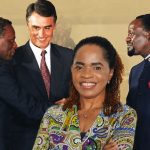 Fotografia histórica registrando o aperto de mão entre o Presidente José Eduardo dos Santos (à esquerda) e o líder da UNITA, Jonas Savimbi (à direita), com a mediação e o sorriso do Primeiro-Ministro português Aníbal Cavaco Silva ao centro, durante a assinatura dos Acordos de Bicesse em Portugal.